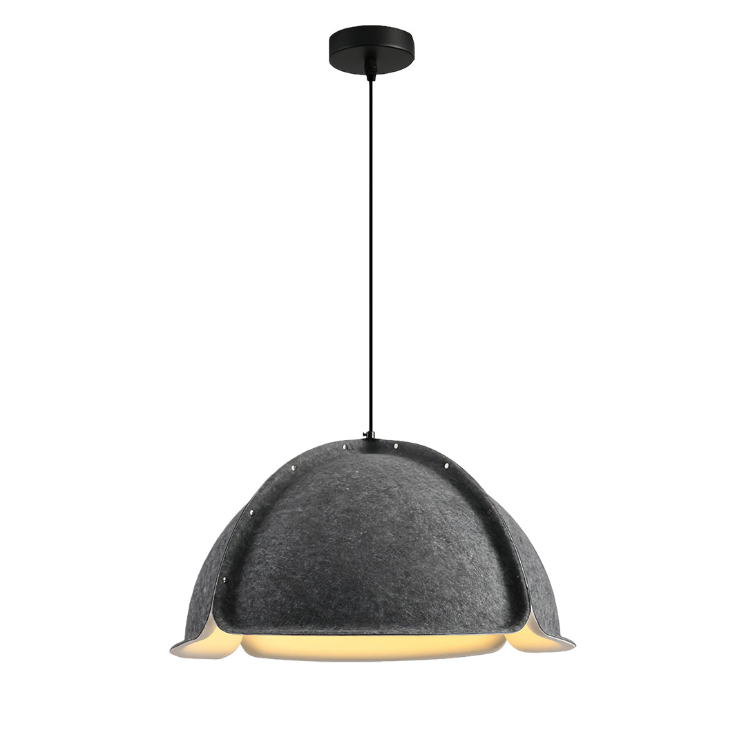 Single orange colored pendant light with an exposed bulb hanging in an artistic cafe setting with sketches and paintings on the wall.