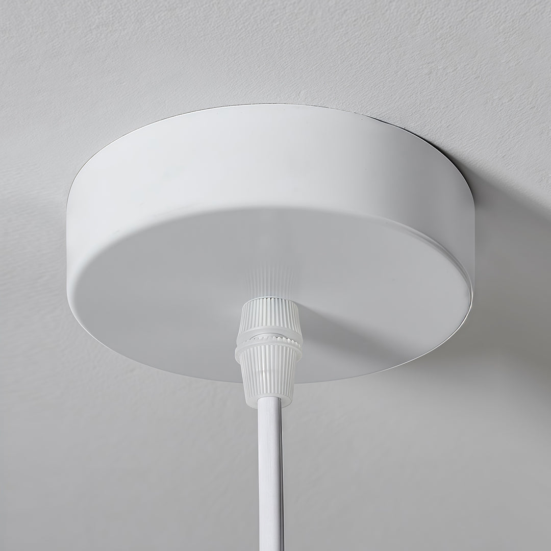 Ceiling canopy of single pendant light fixture in clean white finish with hidden wire connection.