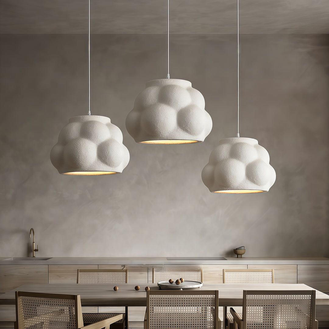 Set of white single pendant light fixture hanging above dining tables in elegant modern restaurant.
