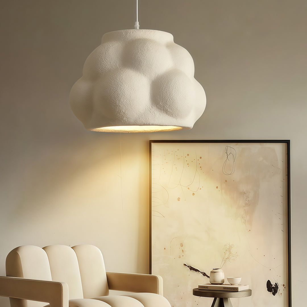 Single pendant light fixture with organic round shape illuminating a minimal living room.