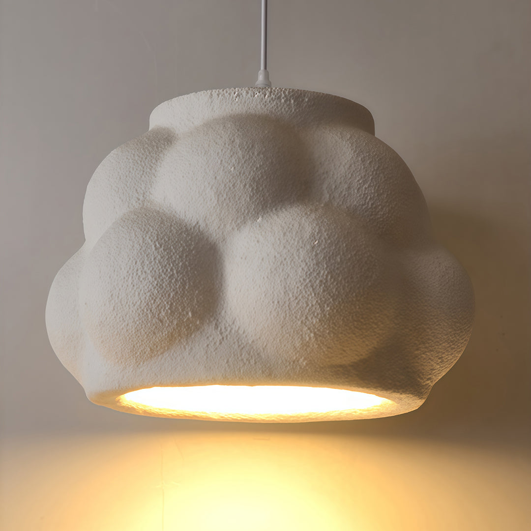 Single pendant light fixture with soft cloud texture and warm downward light, minimalist style.