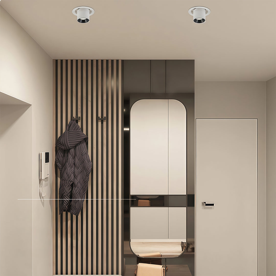 Single white LED ceiling downlights fixture illuminating a modern entryway with slatted wood.
