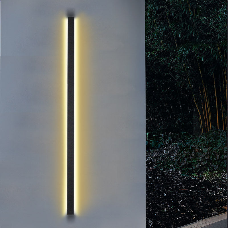 Sleek long black outdoor lights with vertical LED light, installed on a minimalist concrete wall for modern decor.