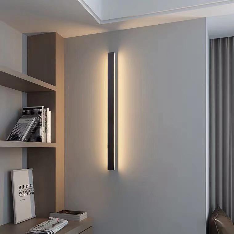 Sleek long outdoor wall lights with warm LED light, installed on minimalist interior wall for modern decor.