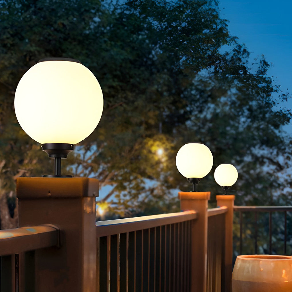 Sleek outdoor gate pillar light with a spherical design, installed on a wooden deck for elegant outdoor lighting.