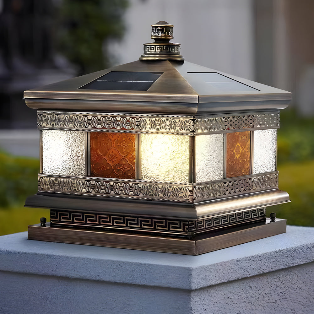 Detailed view of decorative solar column pillar lights with textured glass panels and bronze finish on a concrete pillar.
