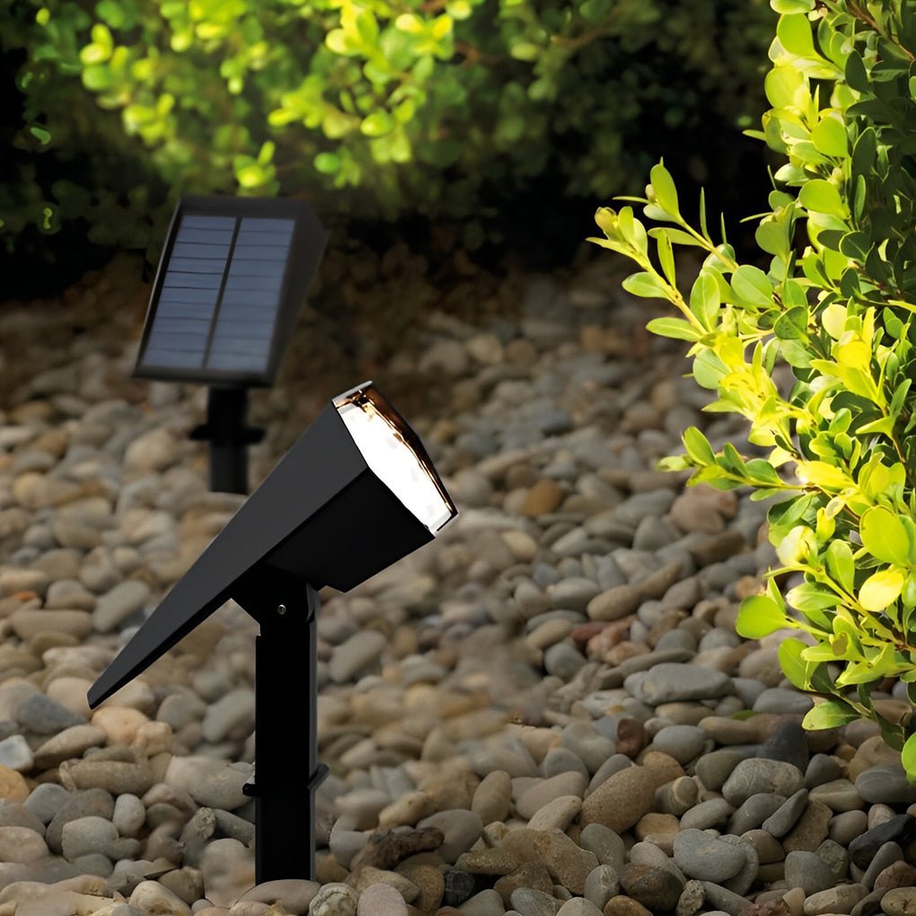 Solar flood spike light installed in garden rocks providing bright white illumination for pathway safety.