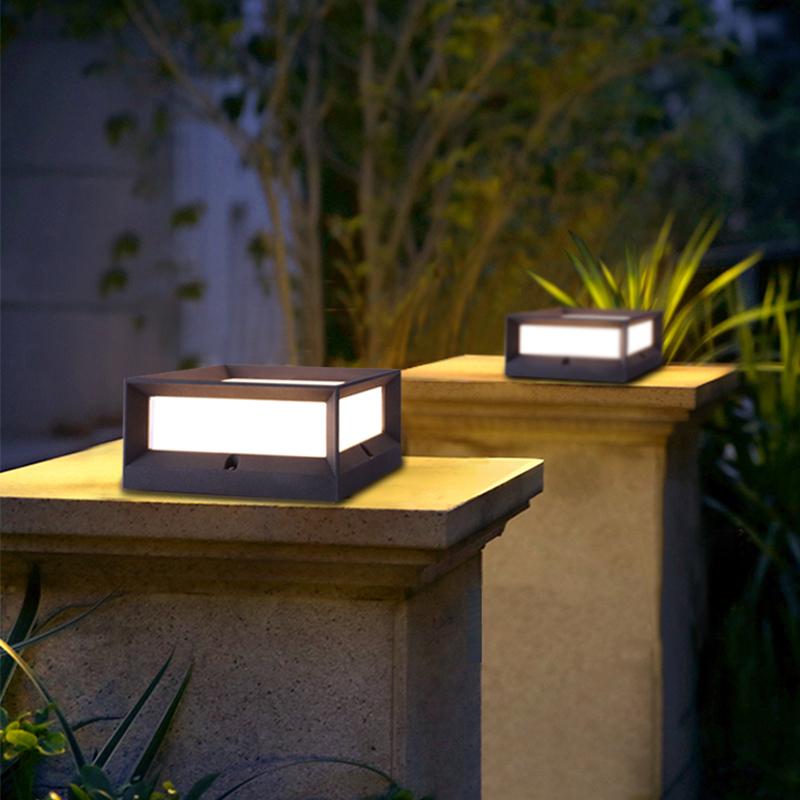 Solar garden pillar lights with black frame, illuminating garden pathway at dusk.