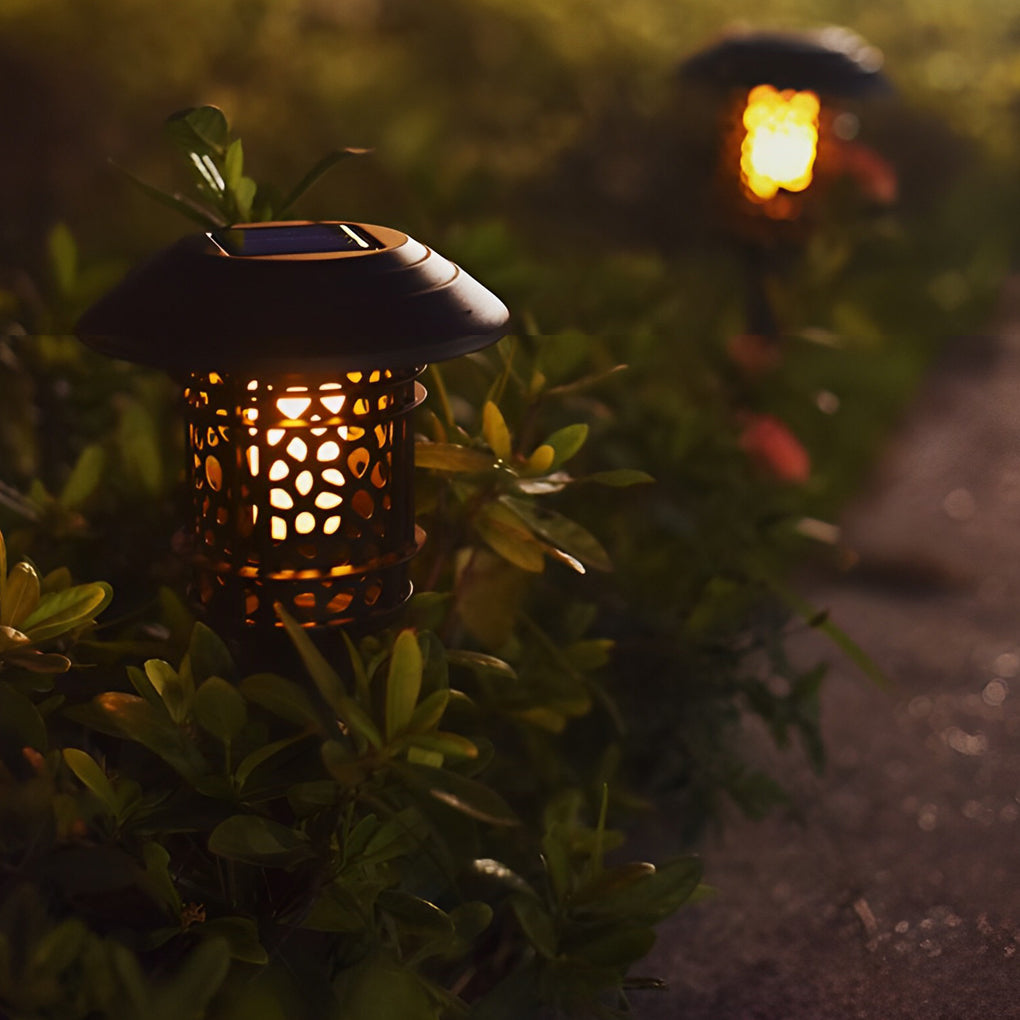Solar path lighting LED placed among shrubs highlighting garden plants at night.