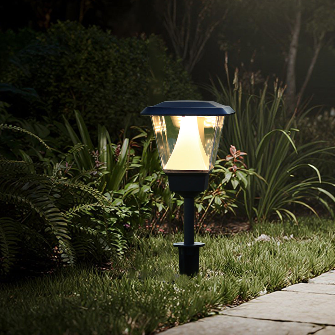 Solar pathway lights providing guidance along concrete walkway with ornamental grass landscaping