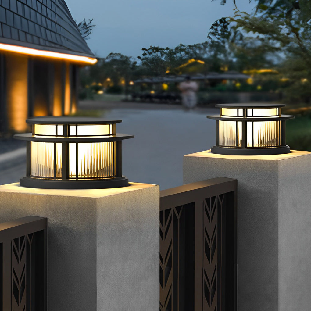 Solar pillar lights mounted on fence posts illuminating driveway at dusk.