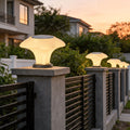 Solar pillar light installed on modern fence posts providing warm outdoor pathway illumination at sunset.
