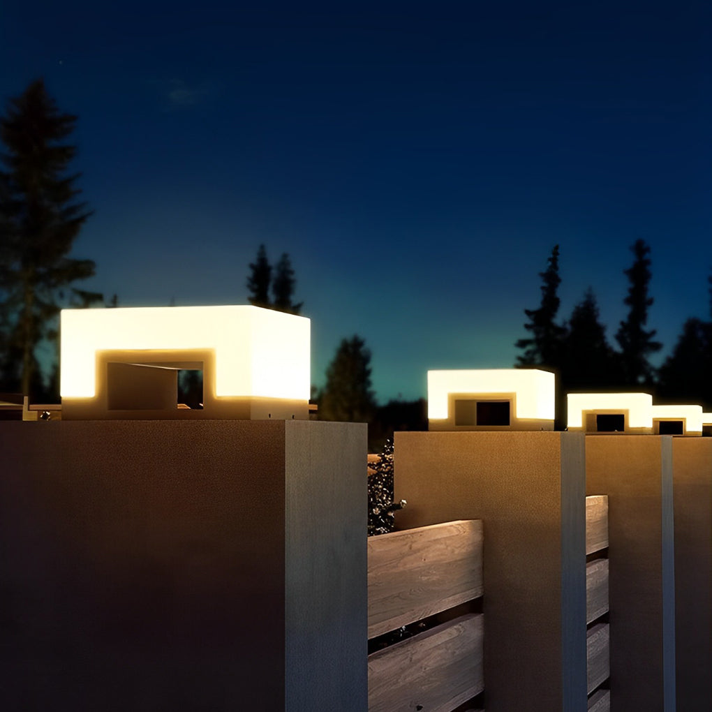 Solar powered front lawn lights illuminating fence posts against night sky.