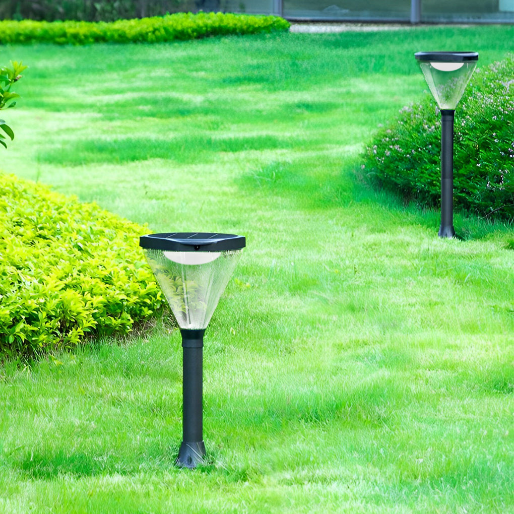 Solar powered lawn light with a modern black finish, illuminating a green lawn.