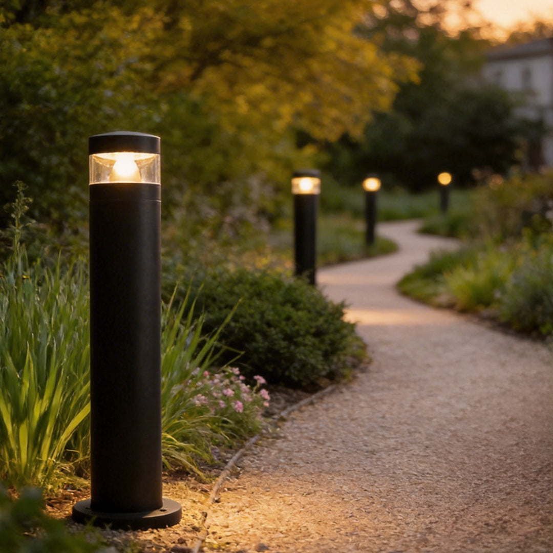 Solar powered LED bollard lights installed along a garden path with warm lighting.