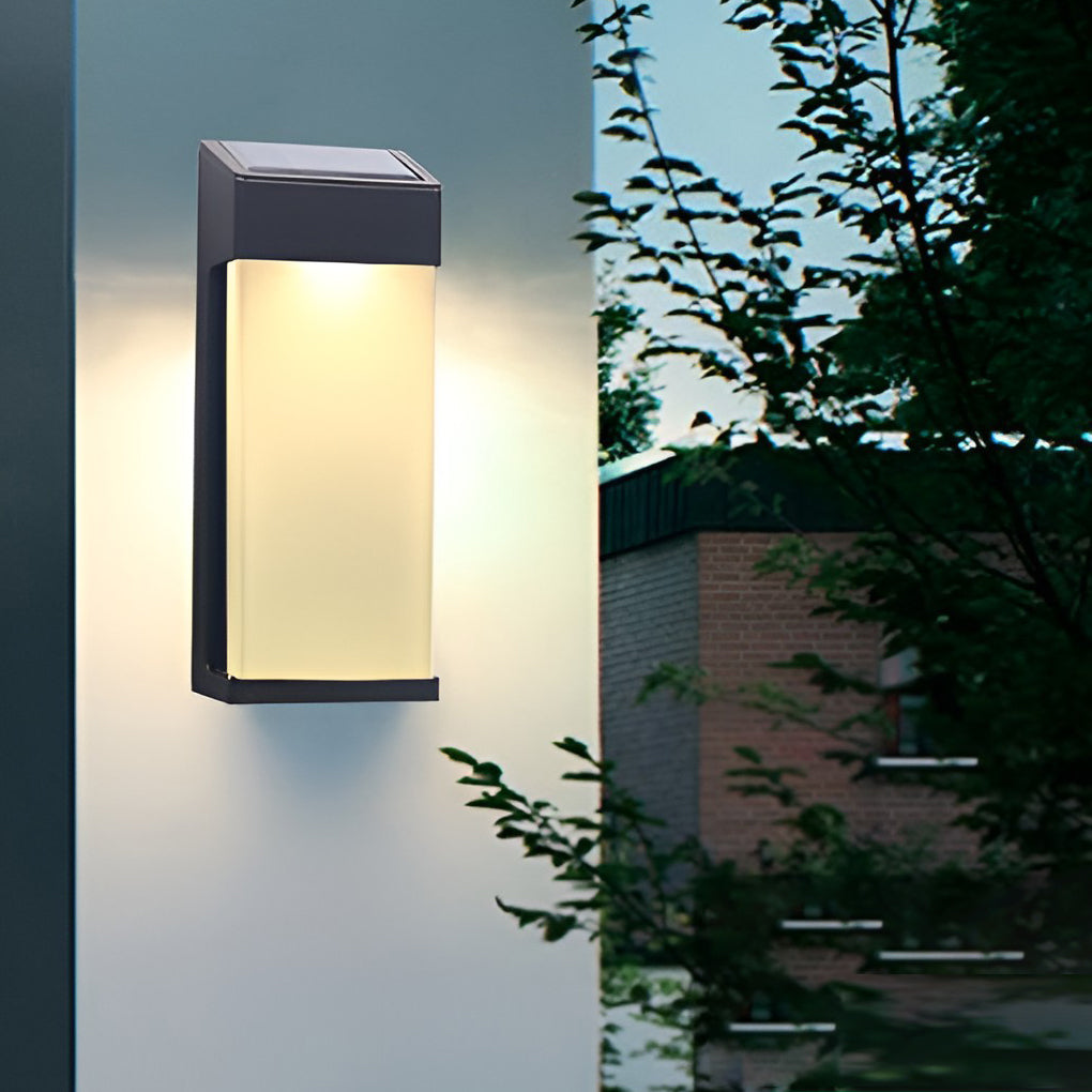 Solar powered outdoor sconces with black frame and warm light near garden plants.