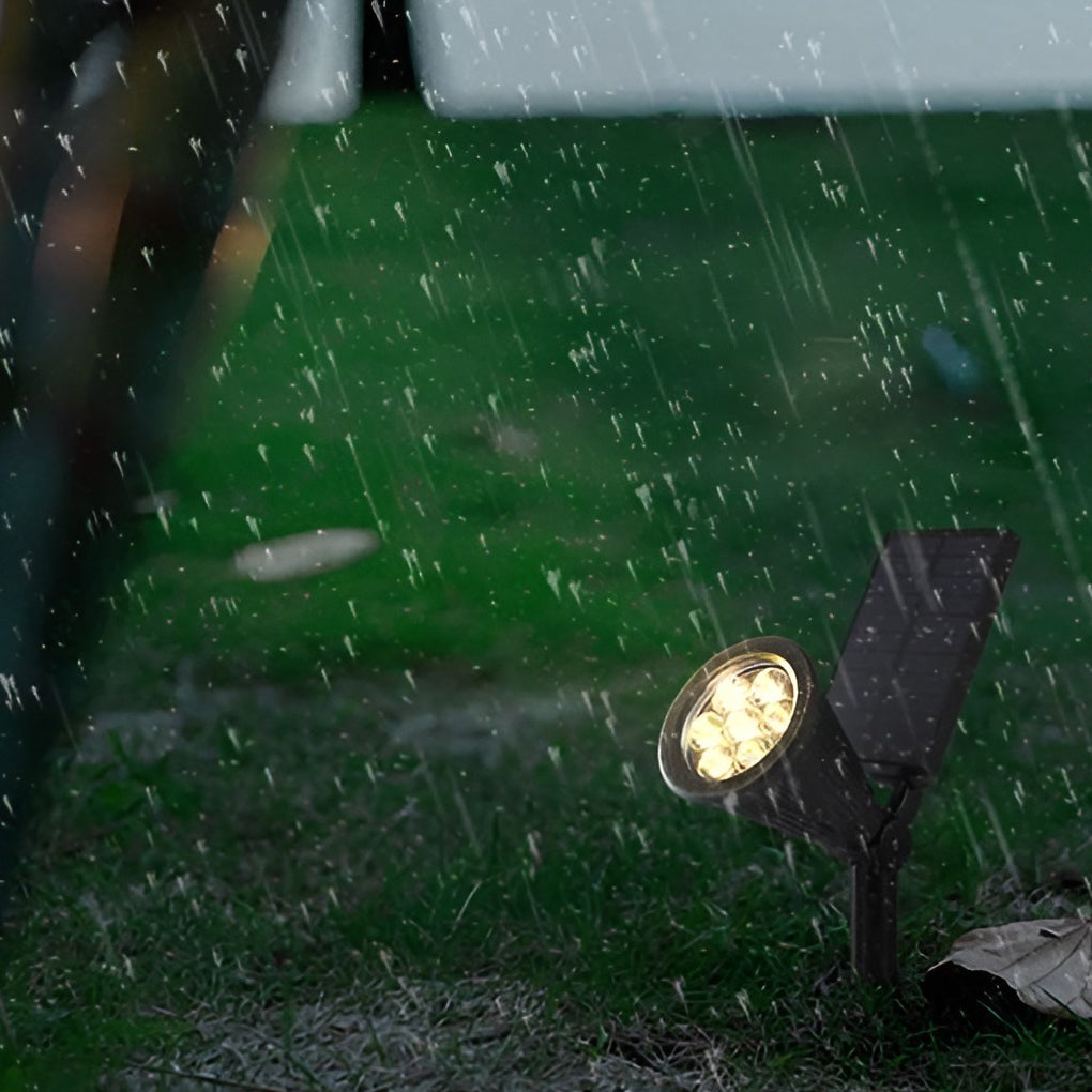 Solar powered spotlights operating in rainy conditions, waterproof outdoor spotlight shining steadily during rainfall.