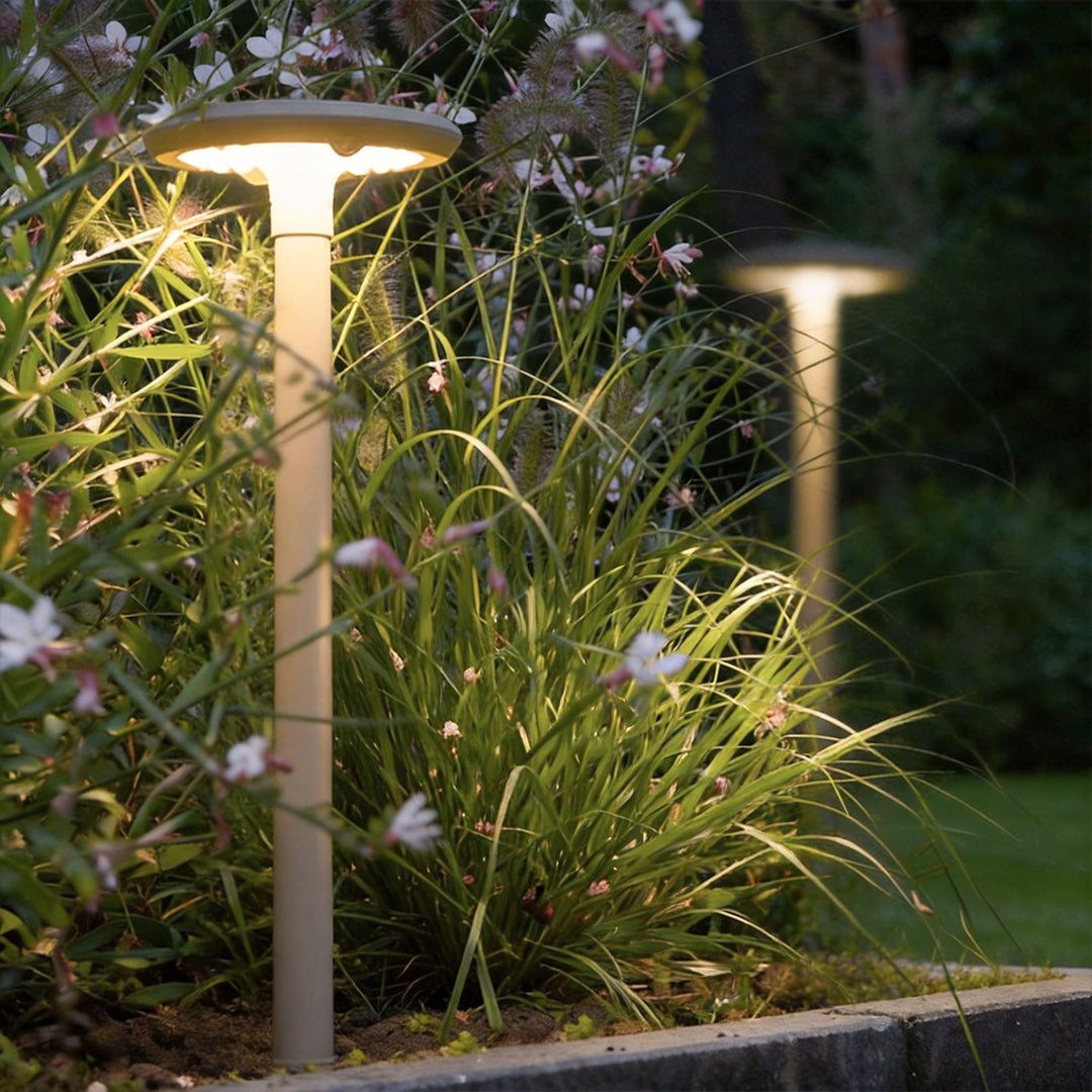 Solar UFO street light with a close-up of its illuminated disc and solar panel in a garden.