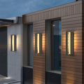 Sophisticated black sconces outdoor with glass shade chandelier influence providing architectural accent lighting on modern brick and concrete building.