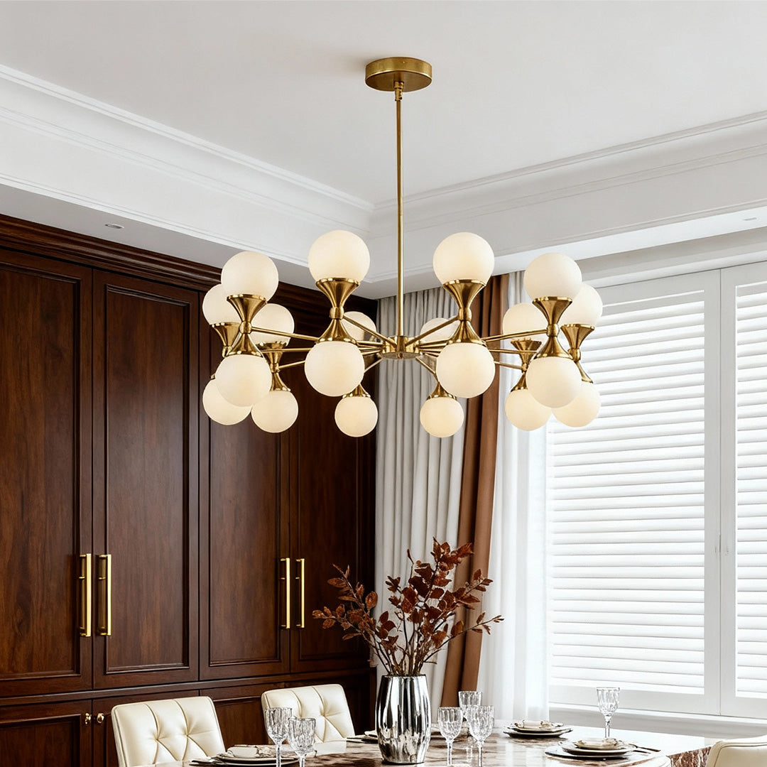 Sophisticated gold bubble glass chandeliers hanging in an elegant room with dark wood cabinetry.