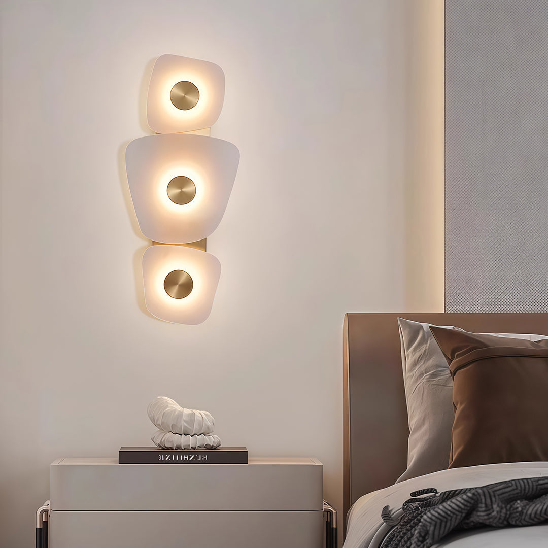 Sophisticated wall art lighted with glass shade chandelier influence providing decorative accent above bed in contemporary bedroom.