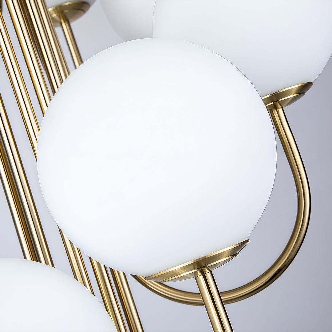 Elegant spiral globe chandelier featuring white frosted glass shades and golden metal arms.