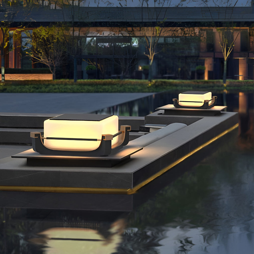 Square acrylic pier light illuminating a garden walkway beside reflective water, enhancing nighttime landscape design.