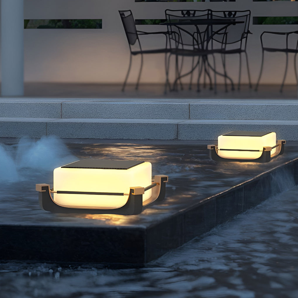 Square acrylic pier light placed near water features, delivering gentle glow along contemporary outdoor steps.