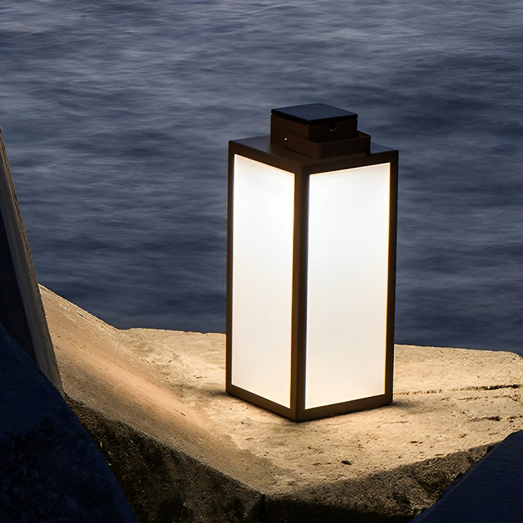 Square handheld lantern with modern design placed on stone steps.