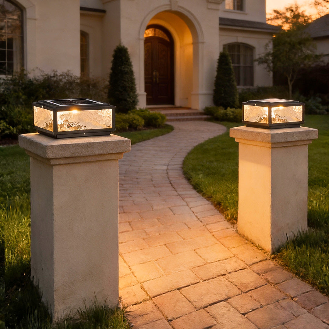 Square outdoor pillar lights lining a garden pathway leading to a luxury home entrance.