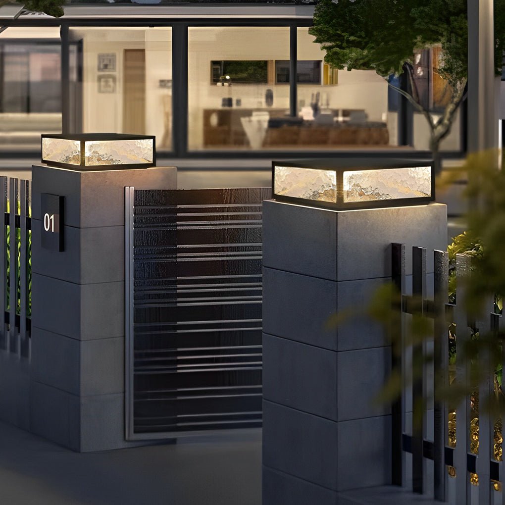 Square outdoor pillar lights positioned at an exterior gate entrance with modern architecture.