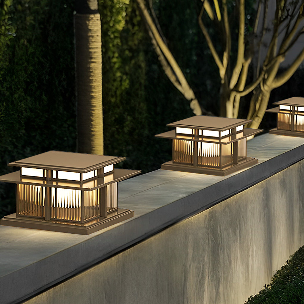 Square outdoor porch pillar lights mounted along a concrete wall for contemporary landscape lighting.