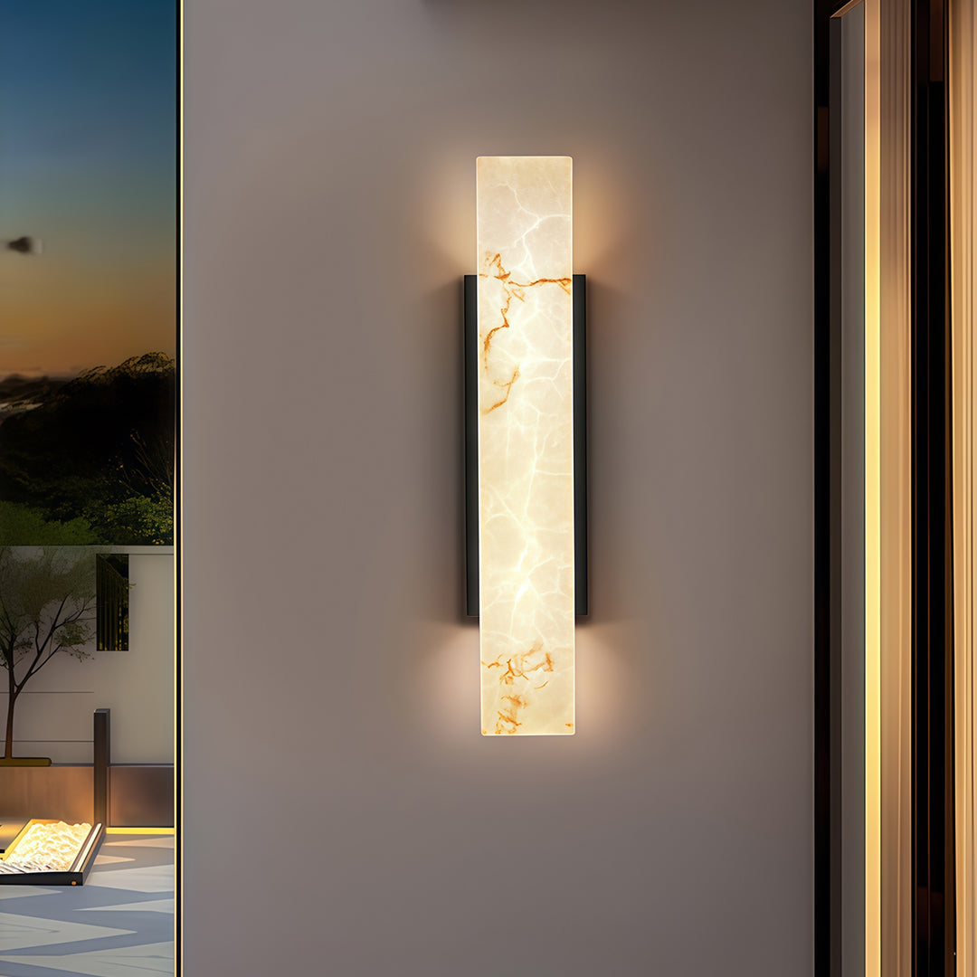 Square outdoor wall lights with a marble finish, providing warm illumination near an entrance at dusk.