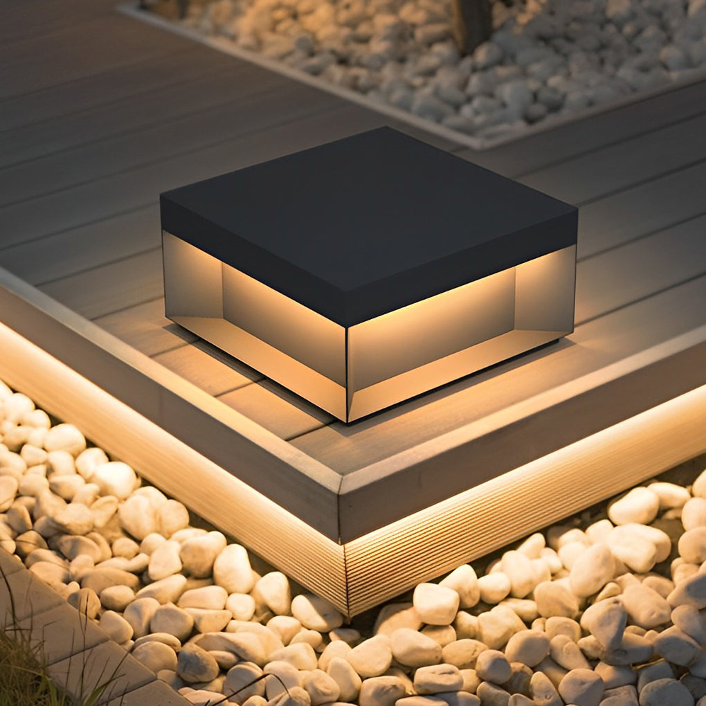 Square solar deck lights illuminating wooden deck corner with warm ambient glow.