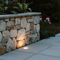 Black cylindrical ground light housing with cutout design for recessed landscape lighting installation