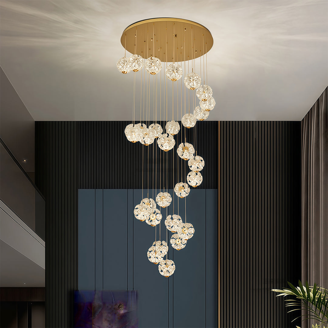 Elegant spiral staircase crystal chandelier in a high-ceiling contemporary interior.