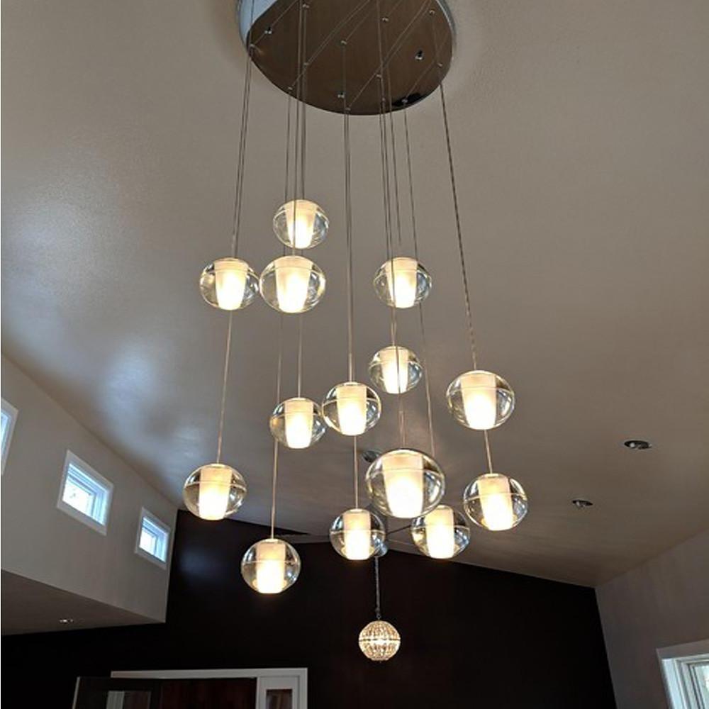 Staircase hanging chandelier casting a gentle glow along a modern staircase.