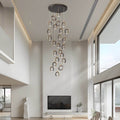 Staircase lighting chandelier with cascading rings, illuminating a modern spiral staircase.