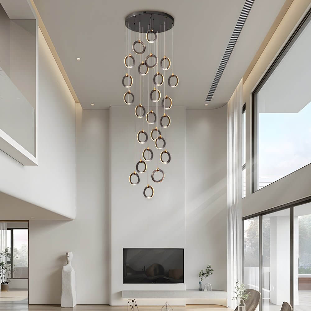 Staircase lighting chandelier with cascading rings, illuminating a modern spiral staircase.