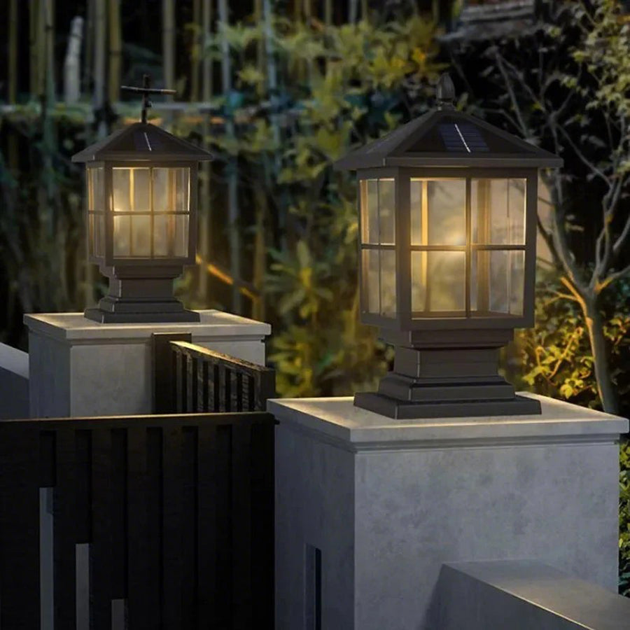 Stone light pillar with a black lantern, providing elegant lighting near a waterfront.