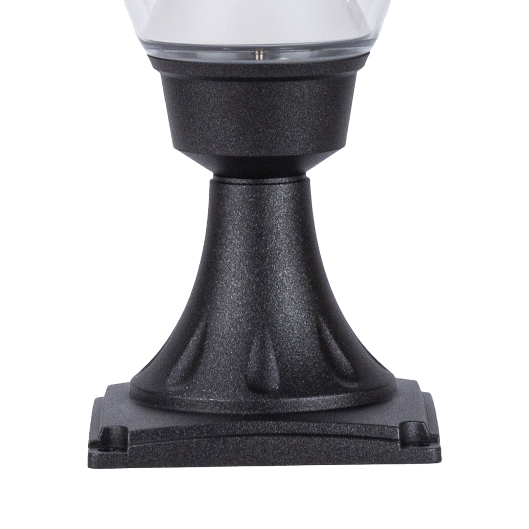 Decorative acorn light fixture mounted on stone surface with landscape lighting