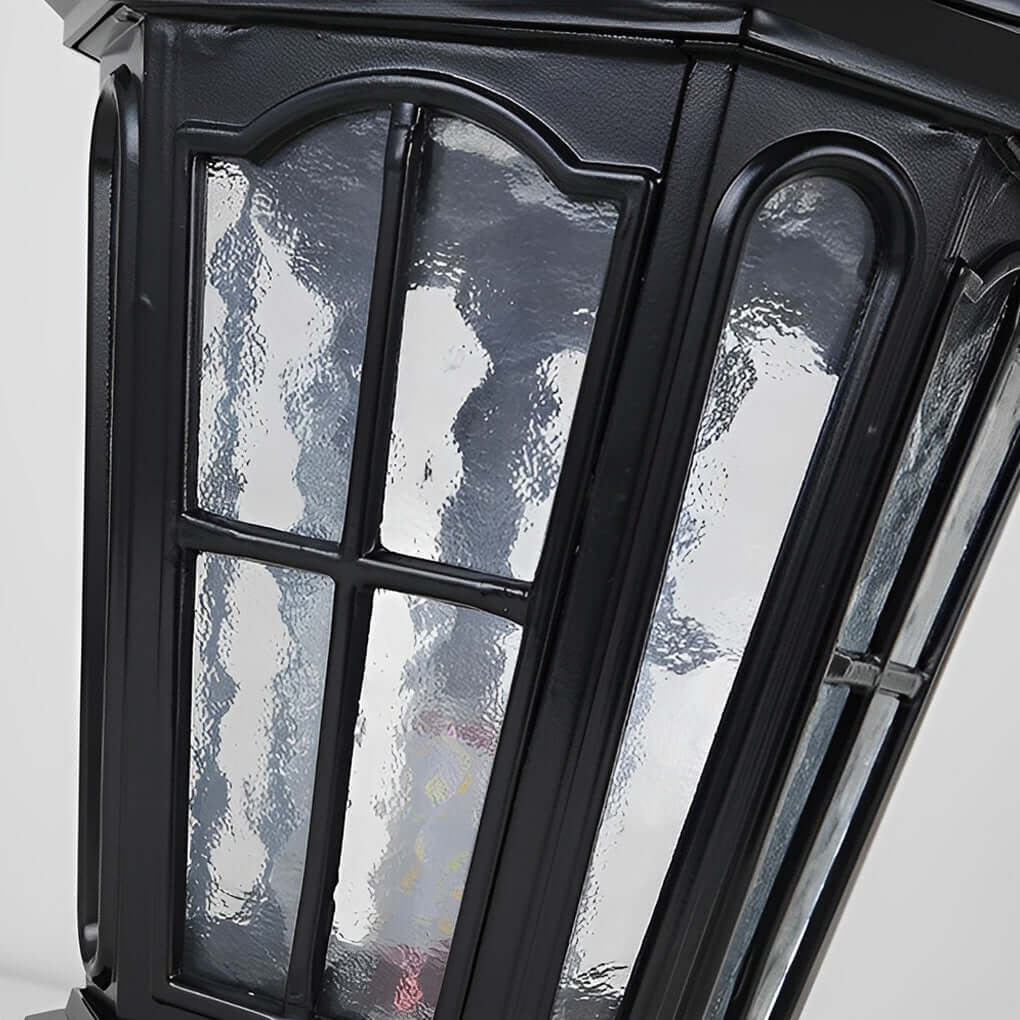 Close up detail of black stone pillar light fixture showing textured glass and metal frame design.