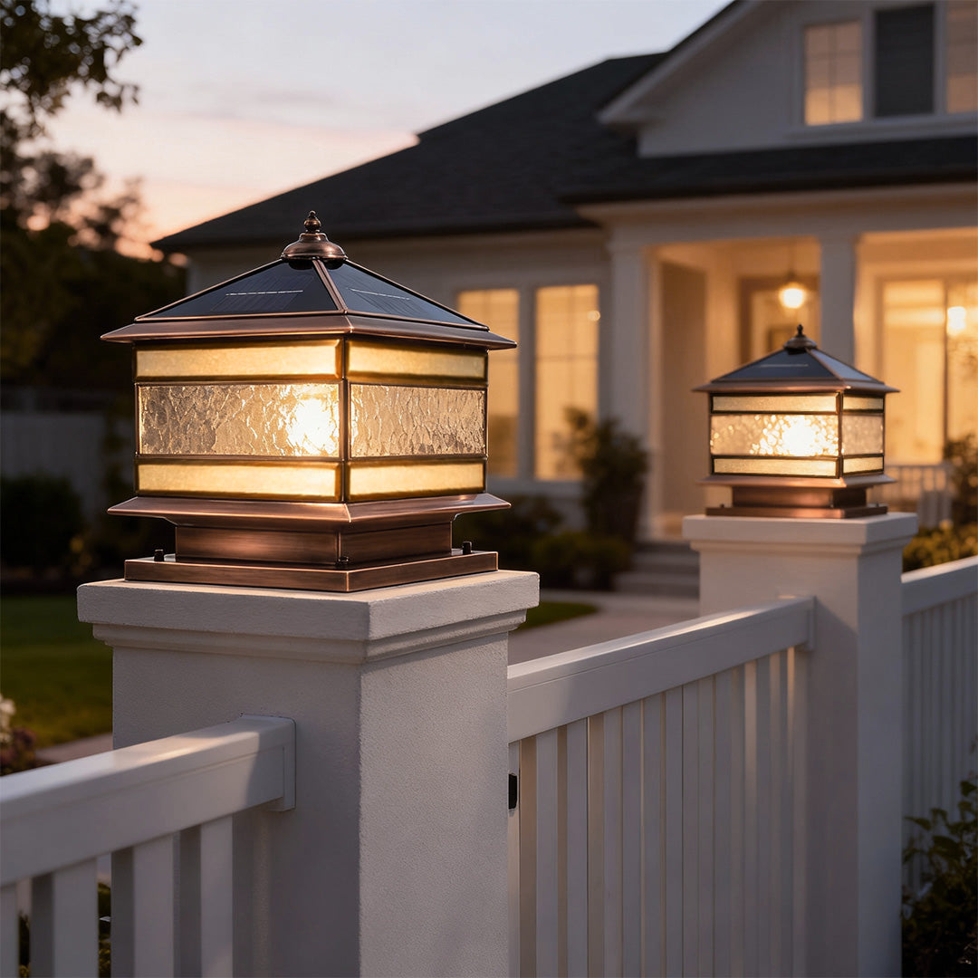 Solar powered stone pillar solar lights installed along a fence for outdoor pathway lighting.
