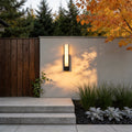 Stone texture wall light with a sleek rectangular design, illuminating a modern house entrance.