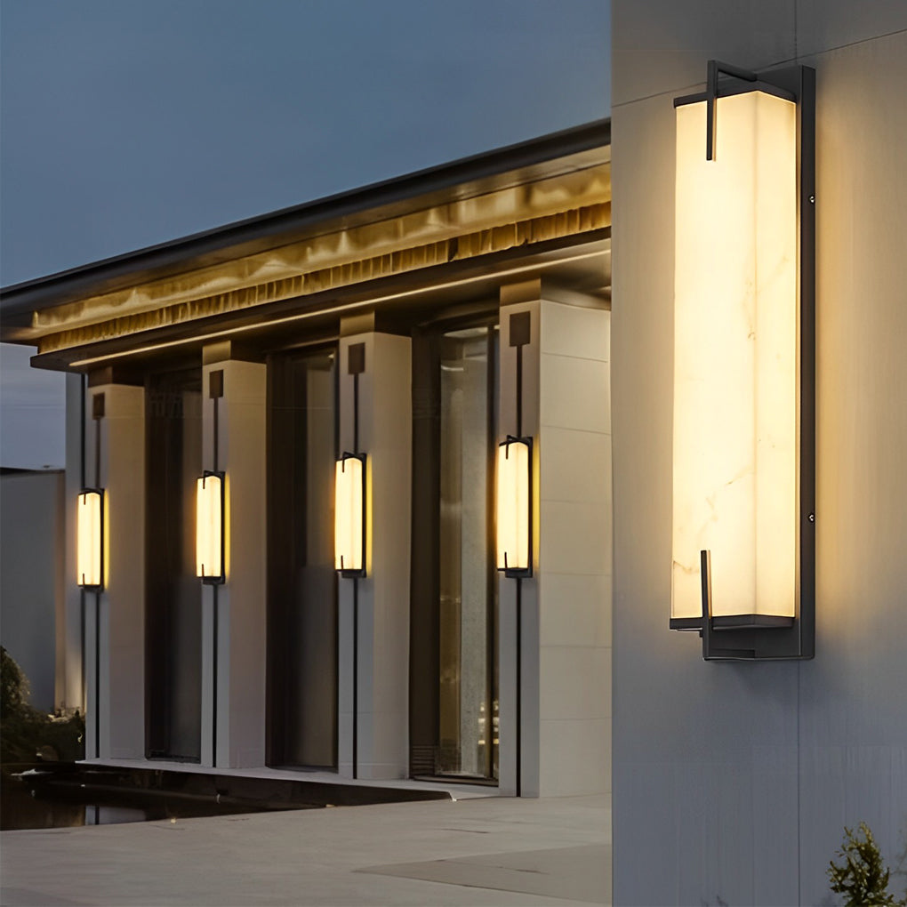 Stone wall sconce lighting near a glass railing, providing a blend of contemporary and classic design.