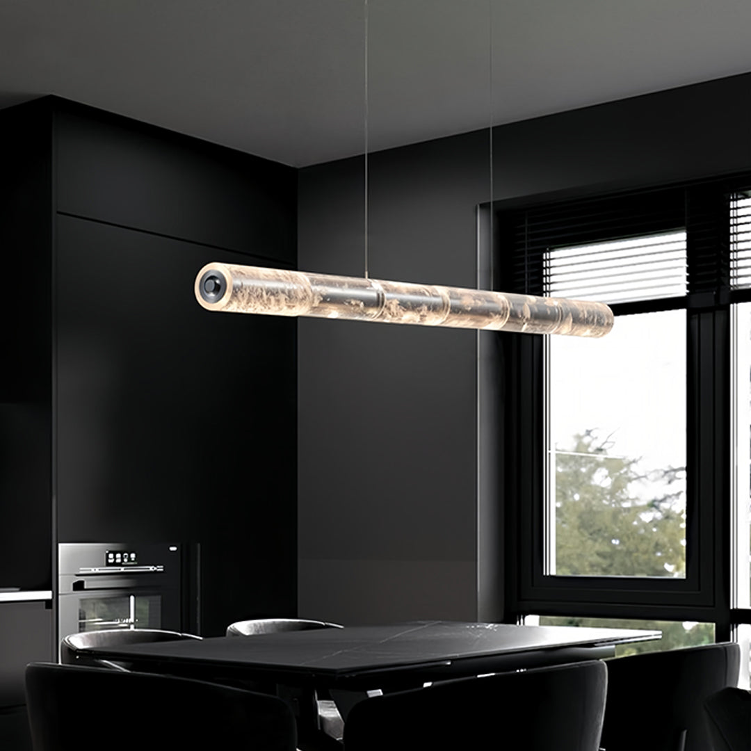 Stylish crystal light pendants featuring a cylindrical crystal body, hanging above a dark dining table.