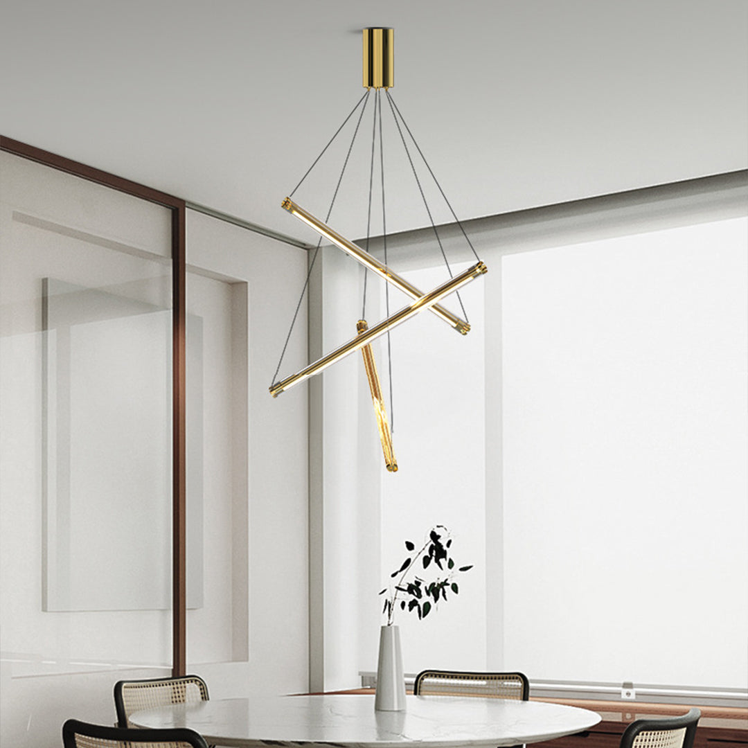 Stylish LED linear chandelier with gold bars and cables, hanging above a minimalist desk in a bright home office.