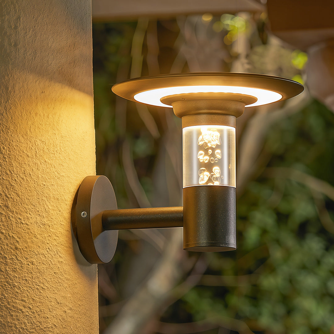 Stylish solar outdoor wall lighting with a unique bubble glass diffuser casting a warm glow on a garden wall.