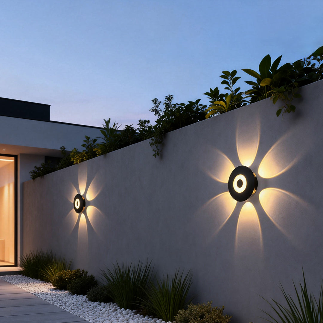 Sunflower LED wall light illuminating a modern garden wall with warm, starburst glow.