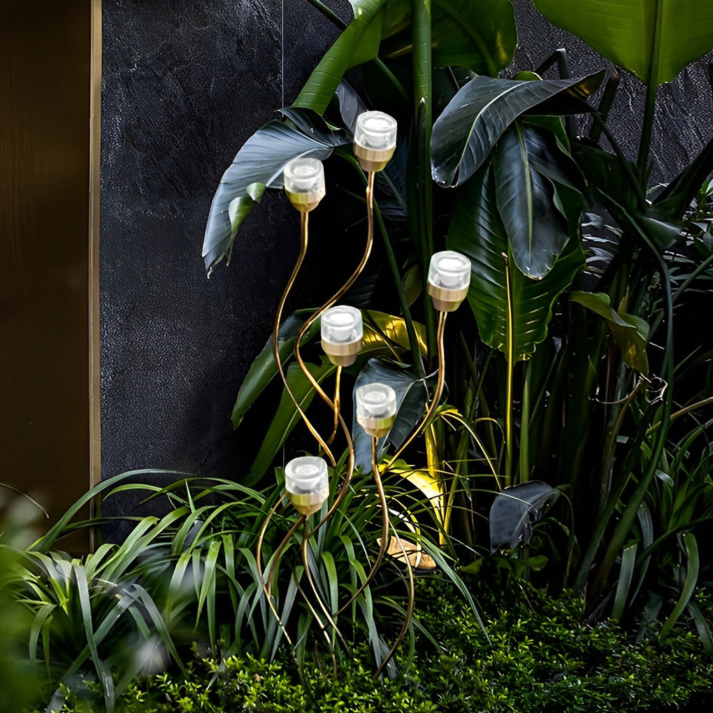 Syphasera standing lamp placed among tropical plants highlighting organic outdoor lighting design.